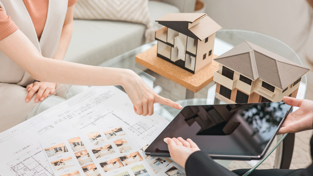 Couple propriétaires consultant documents avec conseiller rénovation énergétique salon maison